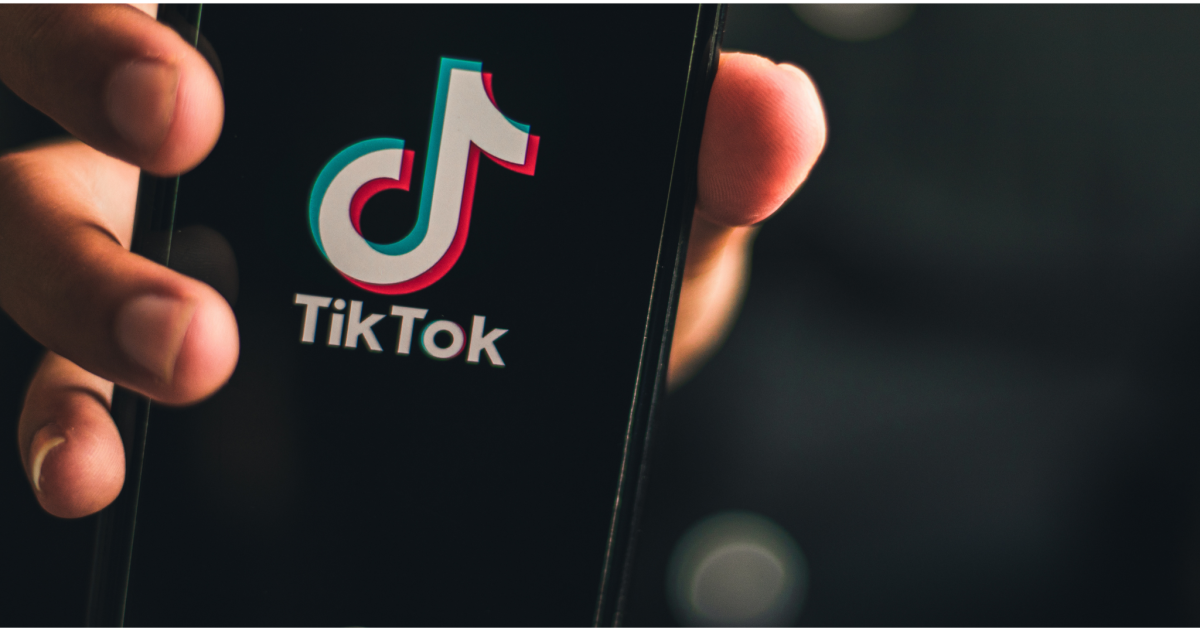 hand holding screen with TikTok app open